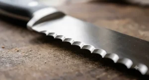 Detailed view of the sharp pointed teeth and scalloped edges on a premium serrated bread knife.