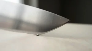 A close-up view of the fine, sharp cutting edge of a polished stainless steel knife